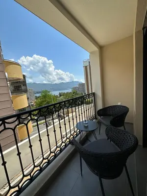a balcony with two chairs and a view of a city at Studio Apartman Dalia in Budva