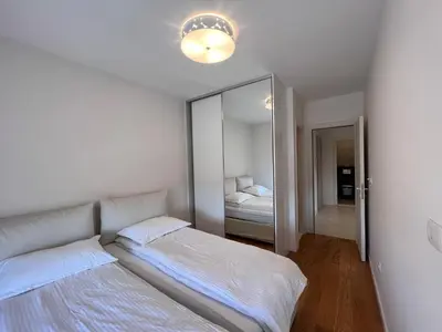 a bedroom with two beds and a mirror at White Homes 37 • Central Point in Podgorica