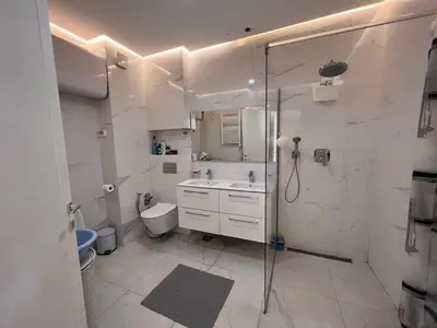 a bathroom with a shower and a toilet and a sink at White Homes 37 • Central Point in Podgorica