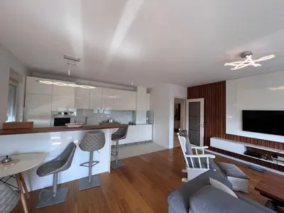 a kitchen and living room with a table and chairs at White Homes 37 • Central Point in Podgorica