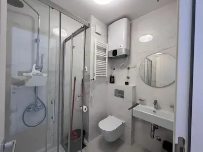 a bathroom with a shower and a toilet and a sink at White Homes 37 • Central Point in Podgorica