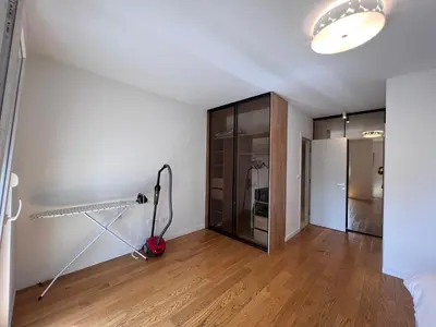 an empty living room with a glass closet and wood floors at White Homes 37 • Central Point in Podgorica
