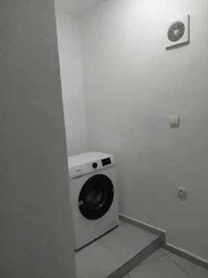 a washer and dryer in a bathroom with a wall at Boggi Apartments in Ulcinj