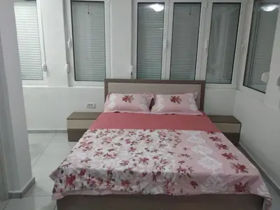 a bedroom with a bed with a red and white blanket at Boggi Apartments in Ulcinj