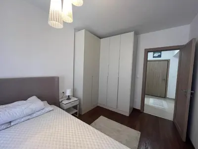 a white bedroom with a bed and a mirror at White Homes 1BR/APT•Master Quart in Podgorica
