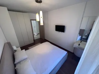 a small bedroom with a white bed and a sink at White Homes 1BR/APT•Master Quart in Podgorica