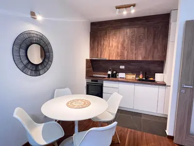 a kitchen with a white table and white chairs at White Homes 1BR/APT•Master Quart in Podgorica