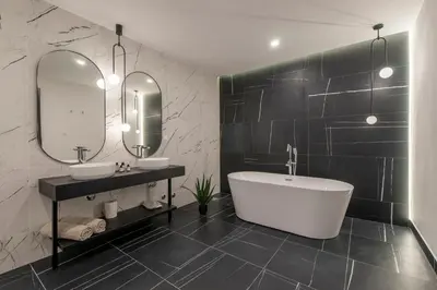 a bathroom with a tub and two sinks and a mirror at Soho Suites in Bar