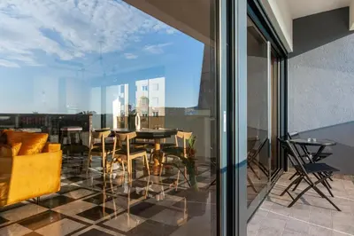 a dining room with a table and chairs on a balcony at Soho Suites in Bar