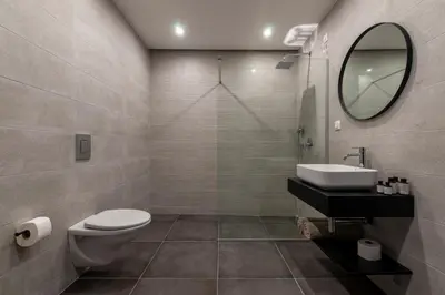 a bathroom with a toilet and a sink and a mirror at Soho Suites in Bar