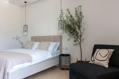 a bedroom with a white bed and a chair at Soho Suites in Bar