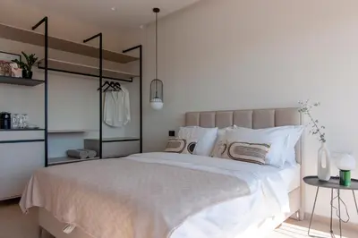 a bedroom with a large bed with white sheets and pillows at Soho Suites in Bar