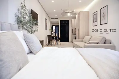 a bedroom with a white bed and a couch at Soho Suites in Bar