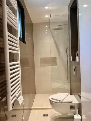 a bathroom with a toilet and a glass shower at Perla apartmani in Petrovac na Moru