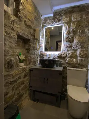 a stone bathroom with a sink and a mirror at Fimas Residence in Ivanovići