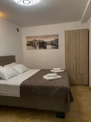 a bedroom with a bed with two towels on it at Fimas Residence in Ivanovići