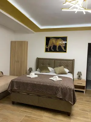 a bedroom with a bed and a painting of a leopard at Fimas Residence in Ivanovići