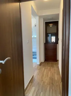 a hallway with a door and a room with wooden floors at Apartment in Becici in Becici