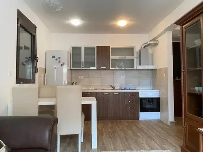 a kitchen with a table and chairs in a room at Apartment in Becici in Becici