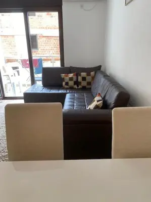 a black leather couch sitting in a living room at Apartment in Becici in Becici