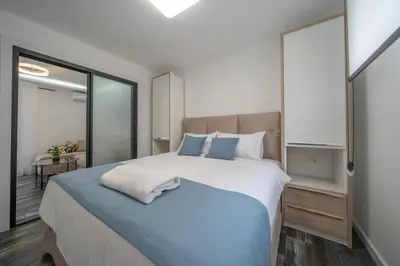 a bedroom with a large bed with a blue blanket at Zoi apartment in Kotor