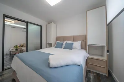 a bedroom with a large bed with blue pillows at Zoi apartment in Kotor