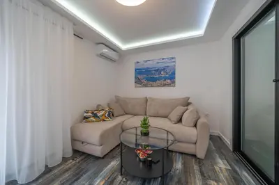 a living room with a couch and a glass table at Zoi apartment in Kotor