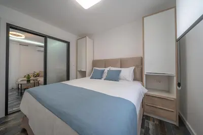 a bedroom with a large bed with blue pillows at Zoi apartment in Kotor