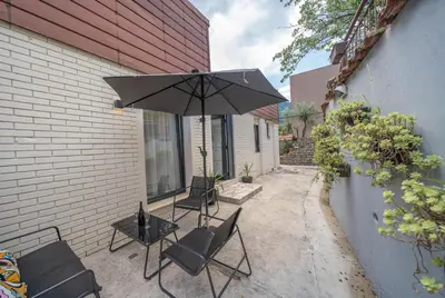 a patio with two chairs and a table with an umbrella at Zoi apartment in Kotor