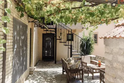 a patio with a table and chairs and a black door at Zoi apartment in Kotor