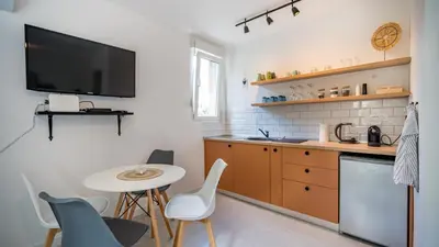 a kitchen with a small table and a tv on the wall at Cozy apartment, 10 minutes walking distance from the Old Town in Kotor