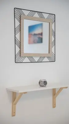 a mirror on a wall above a white shelf at Cozy apartment, 10 minutes walking distance from the Old Town in Kotor