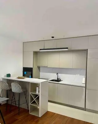 a kitchen with a counter and a sink and chairs at StayPoint Apartment in Podgorica