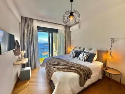 a bedroom with a large bed and a large window at Feel the Spirit Apartment in Budva