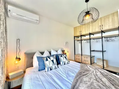 a bedroom with a bed with blue and white pillows at Feel the Spirit Apartment in Budva