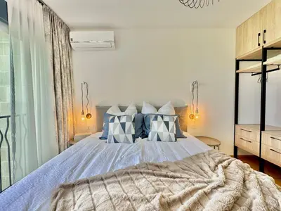 a bedroom with a bed with blue and white pillows at Feel the Spirit Apartment in Budva