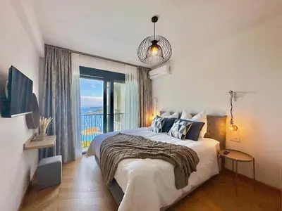 a bedroom with a bed and a large window at Feel the Spirit Apartment in Budva