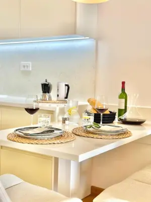 a table with two plates and wine glasses on it at Feel the Spirit Apartment in Budva