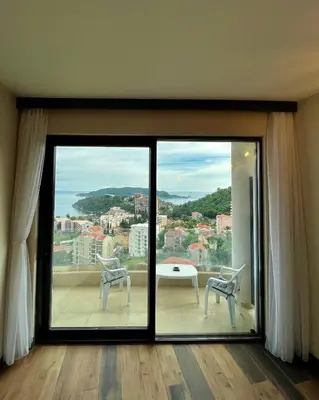 a room with a large window with a table and chairs at Sea & Sky Apartments in Budva
