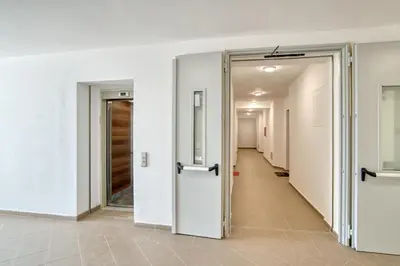 an empty corridor with white walls and doors at Sigma apartment in Budva