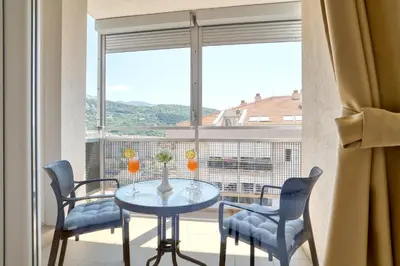 a table and chairs in a room with a large window at Sigma apartment in Budva
