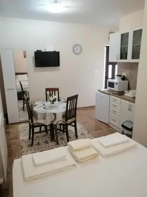 a kitchen and dining room with a table and chairs at Apartman Petovic in Kotor