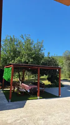 a pavilion with a table and benches in a park at Apartman Petovic in Kotor