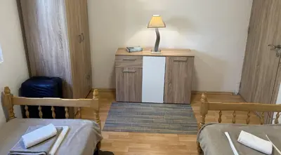 a room with two beds and a table with a lamp at Summer house Kruce in Kruče