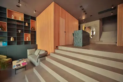a lobby with a staircase with a couch and a chair at Boutique Hotel Shell in Budva