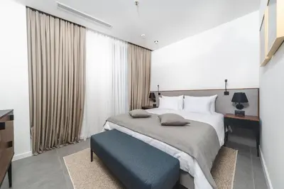 a bedroom with a large bed and a blue bench at Boutique Hotel Shell in Budva
