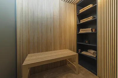 a wooden bench in a closet with a shelf at Boutique Hotel Shell in Budva