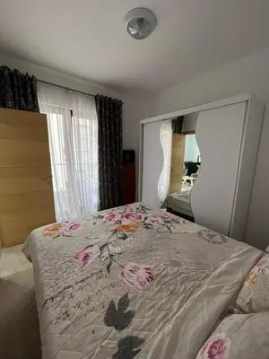 a bedroom with a bed with pink flowers on it at Place Budva in Budva