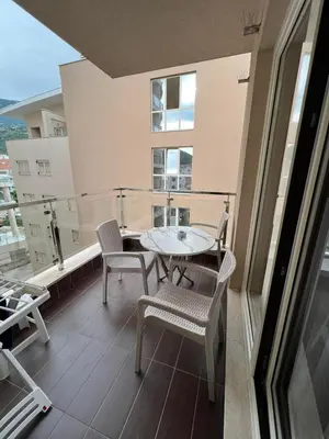 a balcony with a table and chairs on a building at Place Budva in Budva