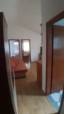 a view of a living room with a couch and a mirror at Apartman Petar in Budva